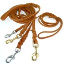 Drei geflochtene Modler Fettlederleinen in hellbraun, dunkelbraun und schwarz in verschiedenen Breiten und mit verschiedenen Bolzenhaken. Im Hintergrund Werkzeuge zum Leinen bauen.